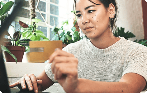 A women using a laptop, with plants in background