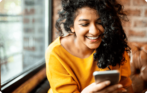 A women smiling looking at her phone
