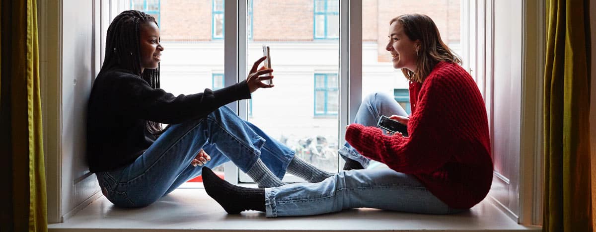 Two women sitting on the floor and having a conversation