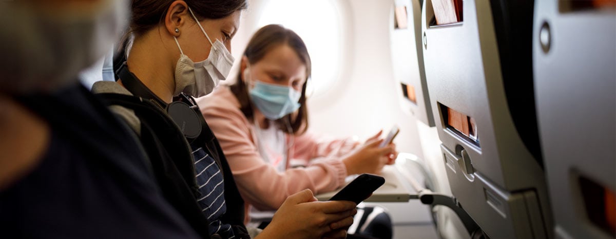 Two women on a flight wearing masks during Covid