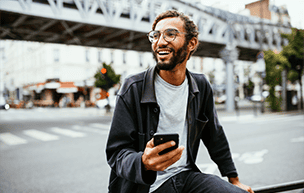 Gen Z man on mobile in cityscape