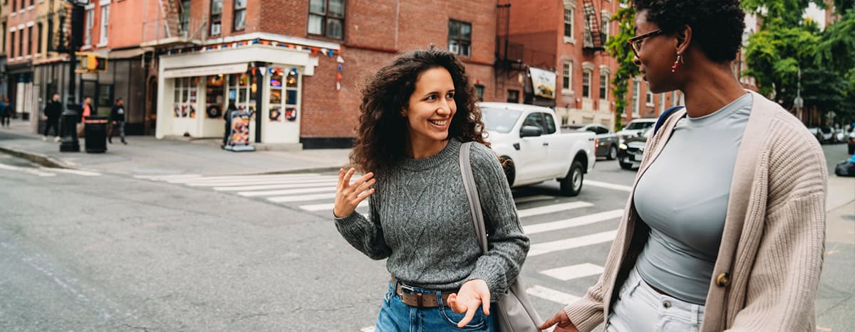 Two professional women walking on the road and talking