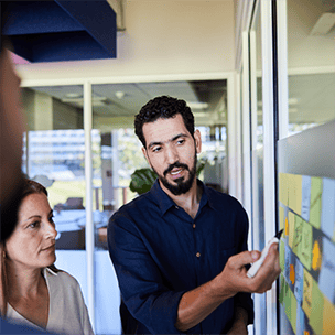 Coworkers with sticky notes in conference room