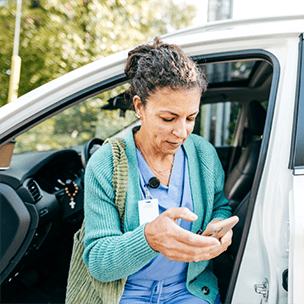 Healthcare provider on phone getting out of car