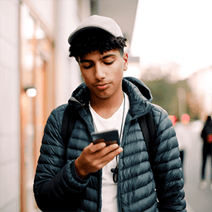 Teen walking down the street on phone