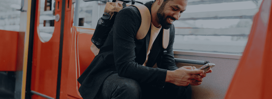 Man on public transit using phone