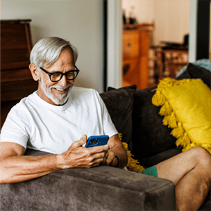 Older man on his phone at home on the couch