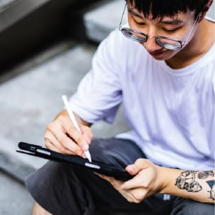 Young man writing on a digital sketch pad