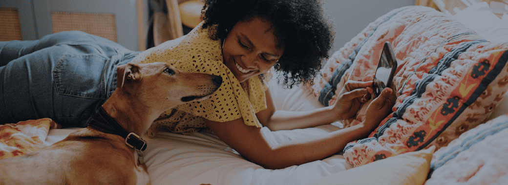 Woman lying on the bed with her dog