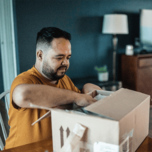 Man opening a package at the table at home