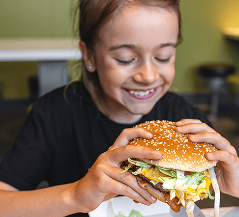 Young girl eating a hamburger