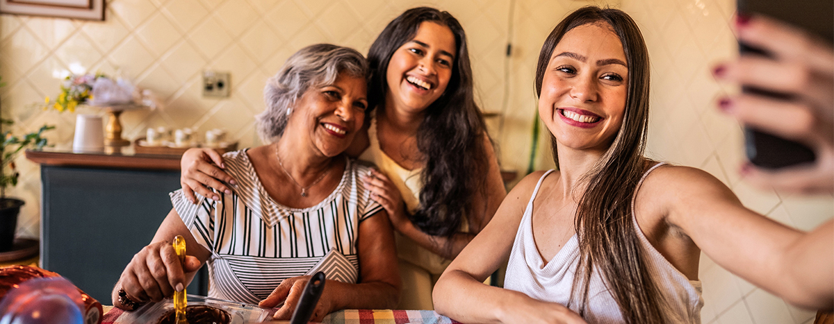 A group of 3 women smiling and clicking a selfie