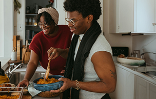 Two individuals cooking in the kitchen