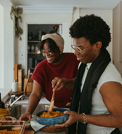 Two individuals cooking in the kitchen