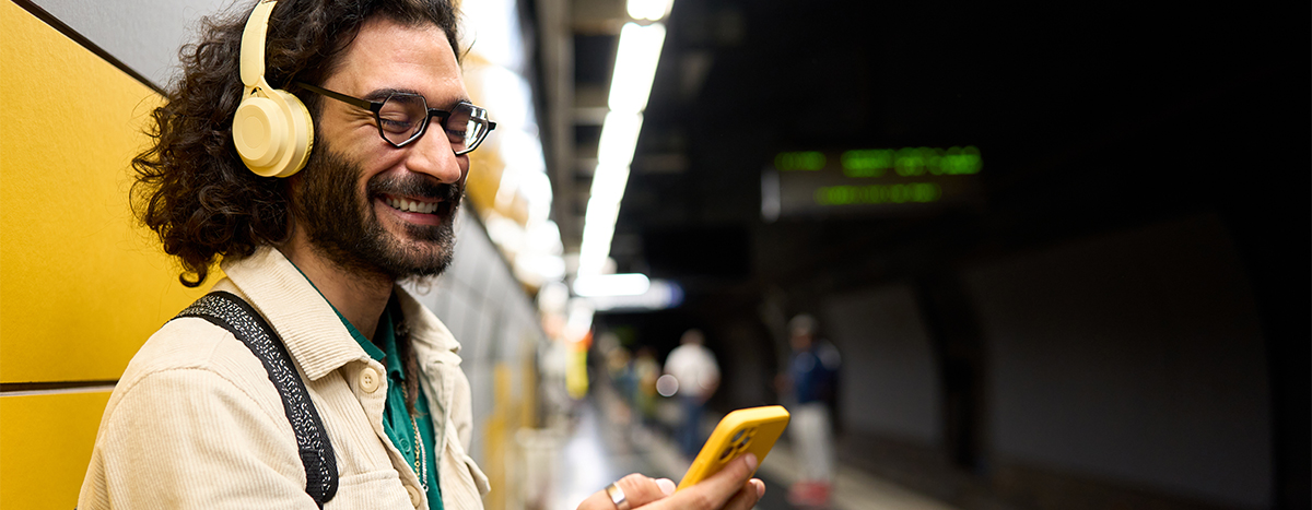 A person using his phone while waiting for the tube.