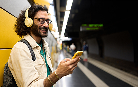 A person using his phone while waiting for the tube.